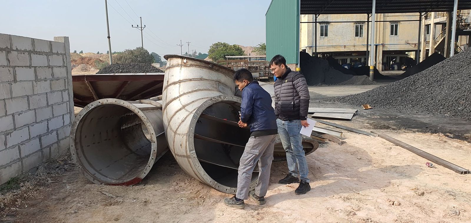 Kỹ sư kiểm tra các đoạn ống dẫn khí nóng của tháp sấy phun sau chế tạo, tại nhà máy